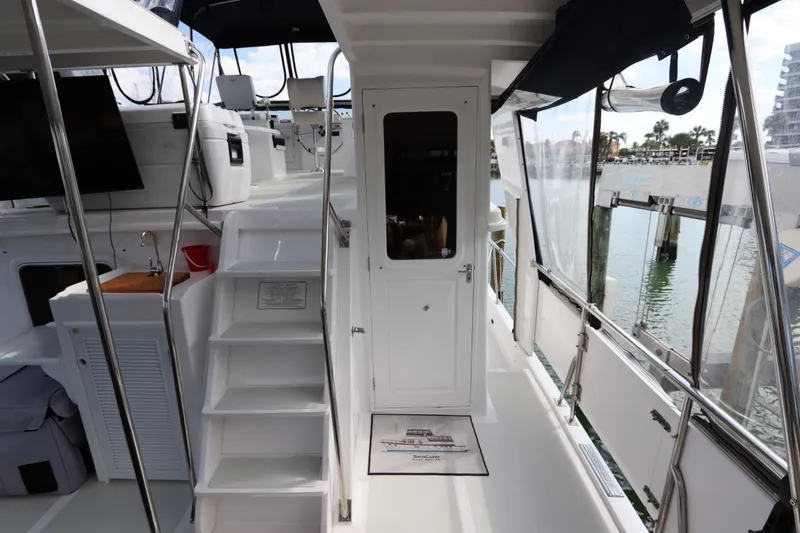 Slide: The Image of 2005 DeFever 49 Cockpit Motor Yacht interior with stairs and marina view. - 27