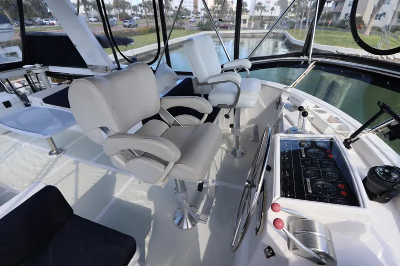 Slide: The Image of 2005 DeFever 49 Cockpit Motor Yacht helm with dual captain chairs and control panel. - 35