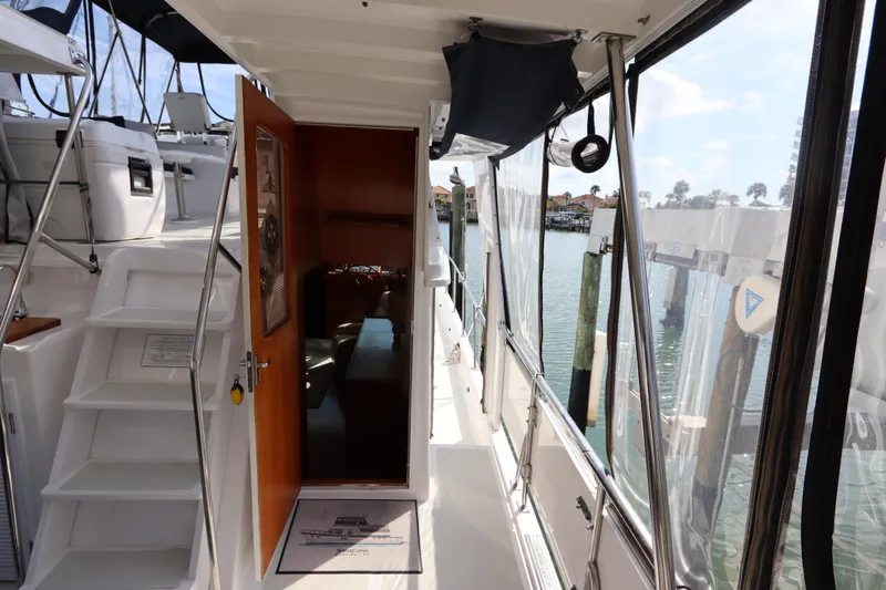 Slide: The Image of 2005 DeFever 49 Cockpit Motor Yacht interior with open door and dockside view. - 45