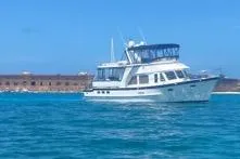 Slide: The Image of 2005 DeFever 49 Cockpit Motor Yacht cruising on clear blue waters. - 5