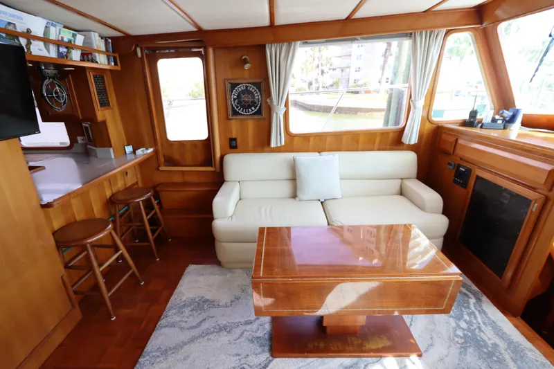 Slide: The Image of Interior of 2005 DeFever 49 Cockpit Motor Yacht with sofa, table, and bar stools. - 53