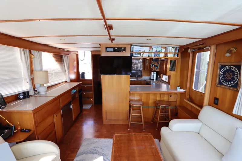 Slide: The Image of Interior of 2005 DeFever 49 Cockpit Motor Yacht with cozy seating and wooden finishes. - 54