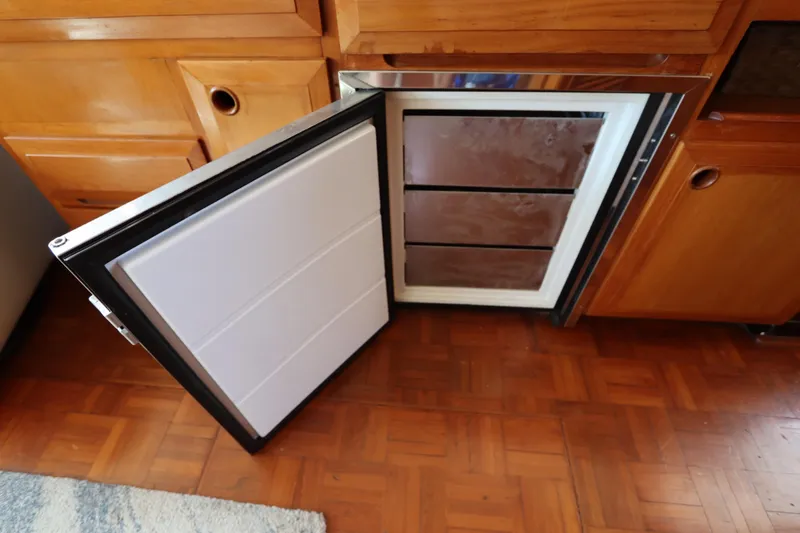 Slide: The Image of Open refrigerator in 2005 DeFever 49 Cockpit Motor Yacht kitchen, wooden cabinetry. - 56