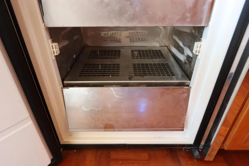 Slide: The Image of Open freezer compartment on 2005 DeFever 49 Cockpit Motor Yacht, showing interior details. - 57