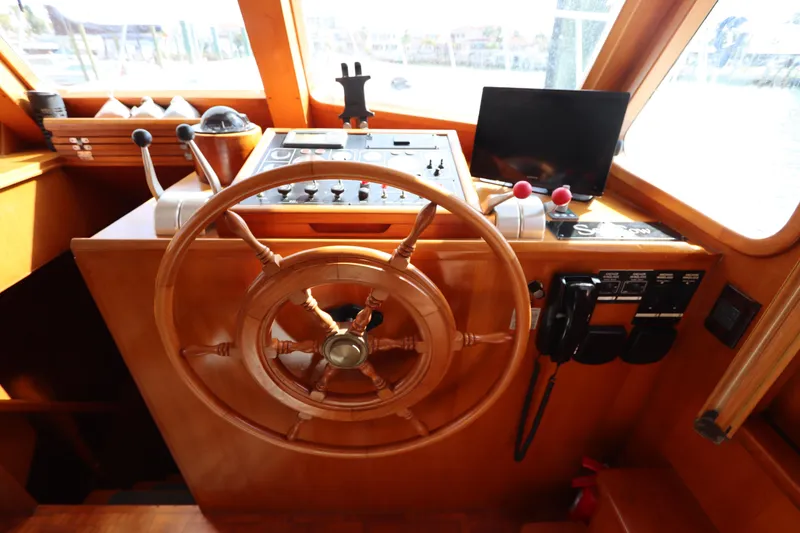 Slide: The Image of Cockpit of 2005 DeFever 49 Cockpit Motor Yacht with wooden steering wheel and controls. - 61