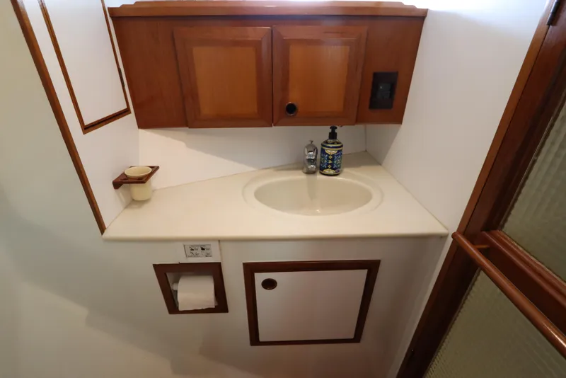 Slide: The Image of Bathroom sink area in a 2005 DeFever 49 Cockpit Motor Yacht with wooden cabinetry. - 78