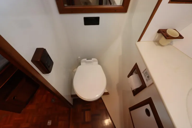 Slide: The Image of Bathroom interior of 2005 DeFever 49 Cockpit Motor Yacht, featuring toilet and wooden accents. - 79