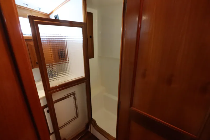 Slide: The Image of Interior of 2005 DeFever 49 Cockpit Motor Yacht bathroom with wooden cabinetry and shower. - 81