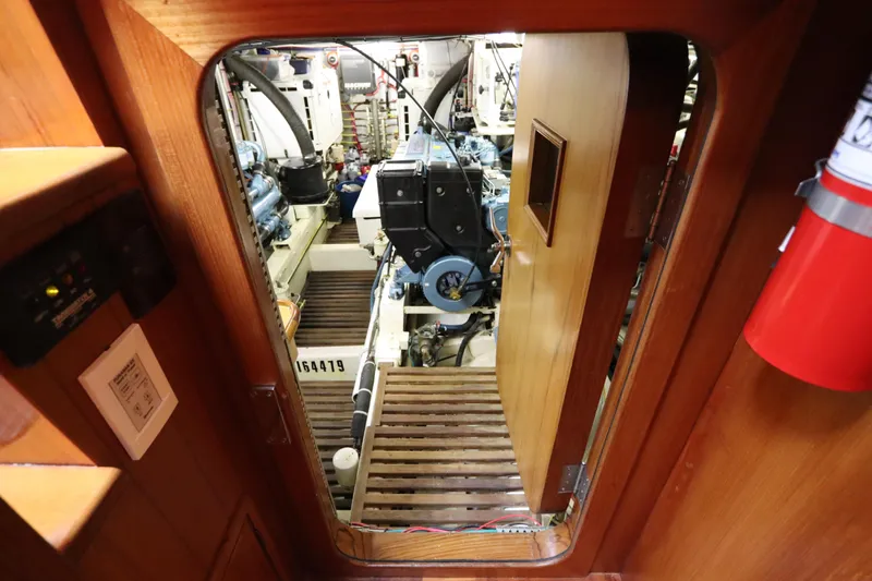 Slide: The Image of Engine room of 2005 DeFever 49 Cockpit Motor Yacht, featuring mechanical components and wooden door. - 84