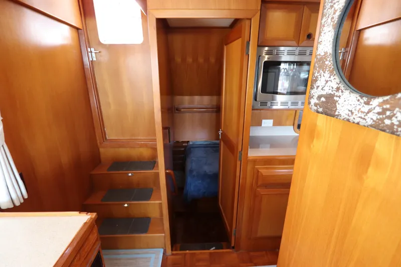 Slide: The Image of 2005 DeFever 49 Cockpit Motor Yacht interior with wooden cabinetry and compact kitchen. - 97