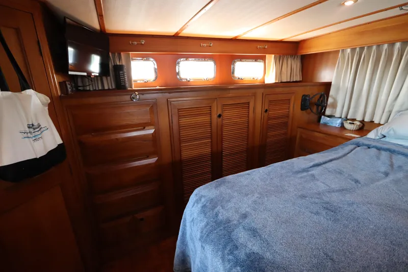 Slide: The Image of Cozy cabin interior of 2005 DeFever 49 Cockpit Motor Yacht with wood paneling and portholes. - 99