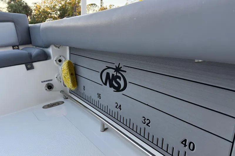 Slide: The Image of 2023 NauticStar 2602 Legacy boat interior with measurement scale and logo. - 20
