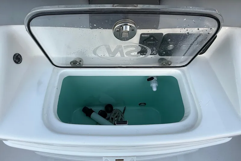 Slide: The Image of Livewell compartment on 2023 NauticStar 2602 Legacy boat, open with accessories inside. - 23