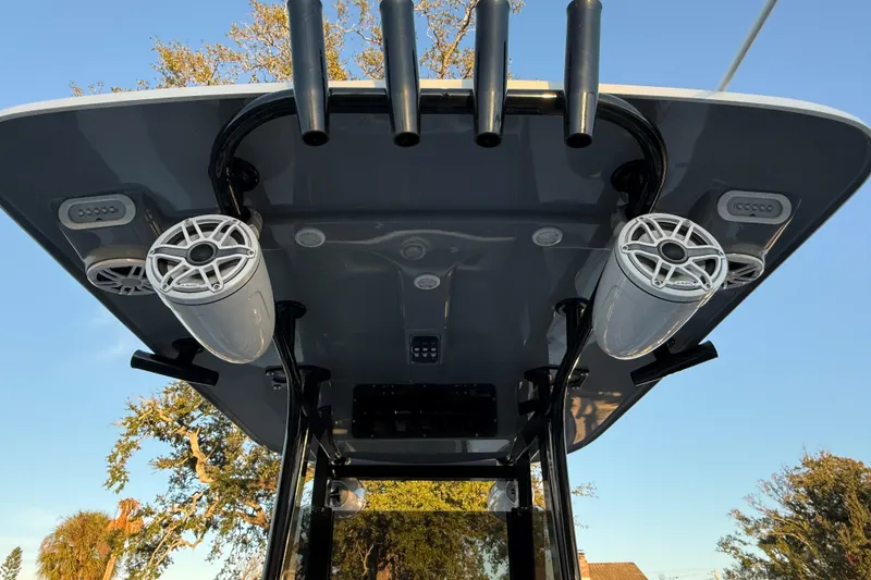 Slide: The Image of 2023 NauticStar 2602 Legacy boat speakers and rod holders under T-top. - 26