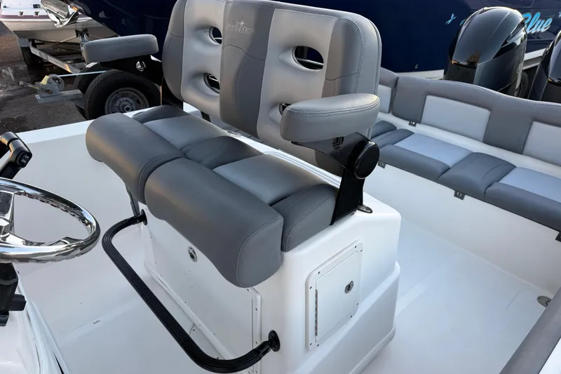 Slide: The Image of 2023 NauticStar 2602 Legacy boat interior with gray seating and steering wheel. - 30
