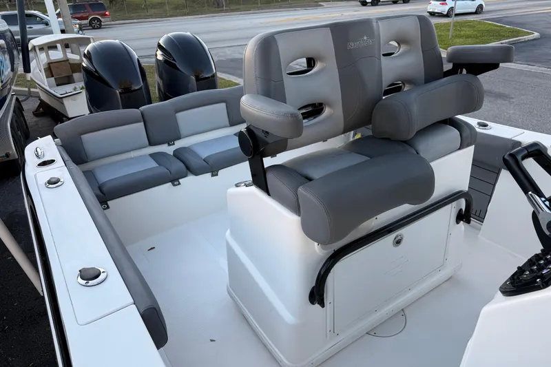 Slide: The Image of 2023 NauticStar 2602 Legacy boat interior with dual engines and cushioned seating. - 31