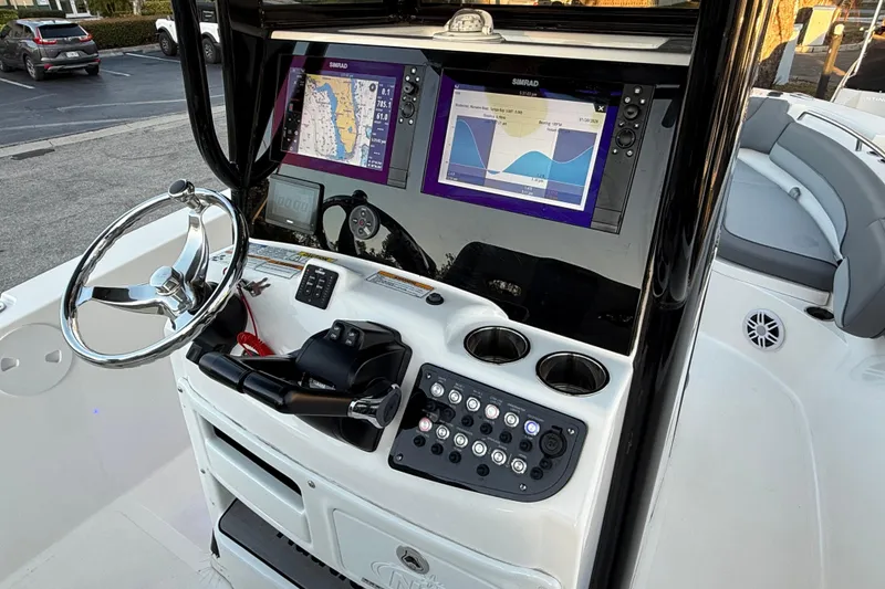 Slide: The Image of 2023 NauticStar 2602 Legacy boat dashboard with navigation screens and controls. - 37