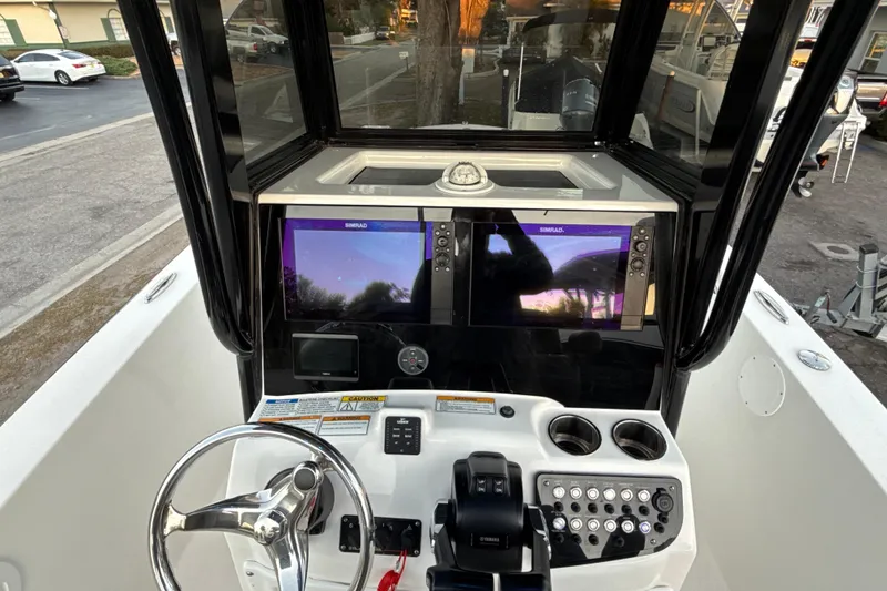 Slide: The Image of 2023 NauticStar 2602 Legacy boat dashboard with dual Simrad displays and steering wheel. - 41