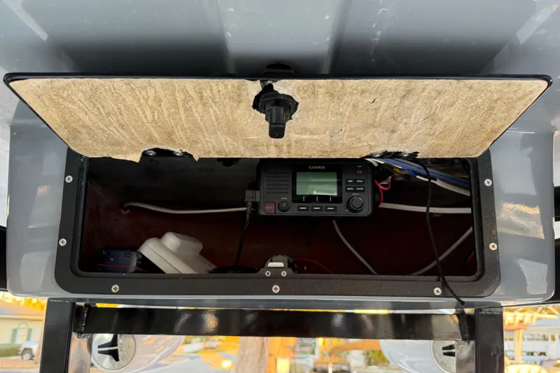 Slide: The Image of Open storage compartment on 2023 NauticStar 2602 Legacy boat with Garmin device inside. - 43