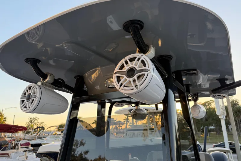 Slide: The Image of 2023 NauticStar 2602 Legacy boat speakers under T-top at sunset. - 48