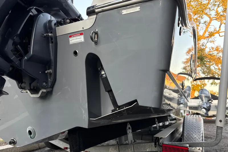 Slide: The Image of 2023 NauticStar 2602 Legacy boat stern with motor and trailer detail. - 5