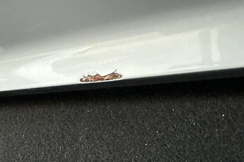 Slide: The Image of Close-up of a 2023 NauticStar 2602 Legacy with visible paint damage. - 61