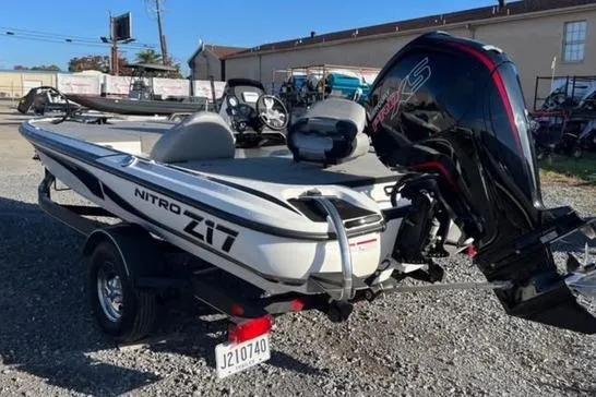 Slide: The Image of 2024 Nitro Z17 boat with powerful outboard motor, parked on gravel lot. - 3