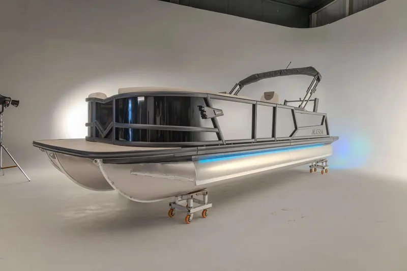 Slide: The Image of 2026 Alera M 25L pontoon boat on trailer, parked outdoors. - 1