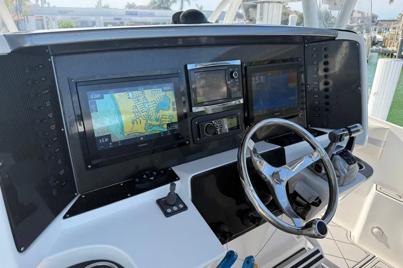 Slide: The Image of 2014 Nor-Tech 340 Sport Center Console dashboard with navigation screens and steering wheel. - 10