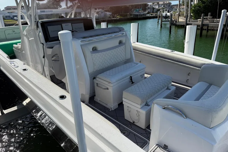 Slide: The Image of 2014 Nor-Tech 340 Sport Center Console boat interior with white seating and Garmin displays. - 6