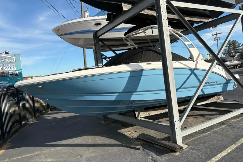 Slide: The Image of 2026 Chaparral GTS 3 boat in storage, light blue hull, outdoor display. - 2