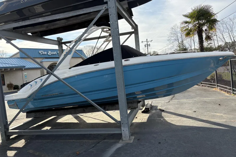 Slide: The Image of 2026 Chaparral GTS 3 boat in blue, displayed on a rack at a dealership. - 3