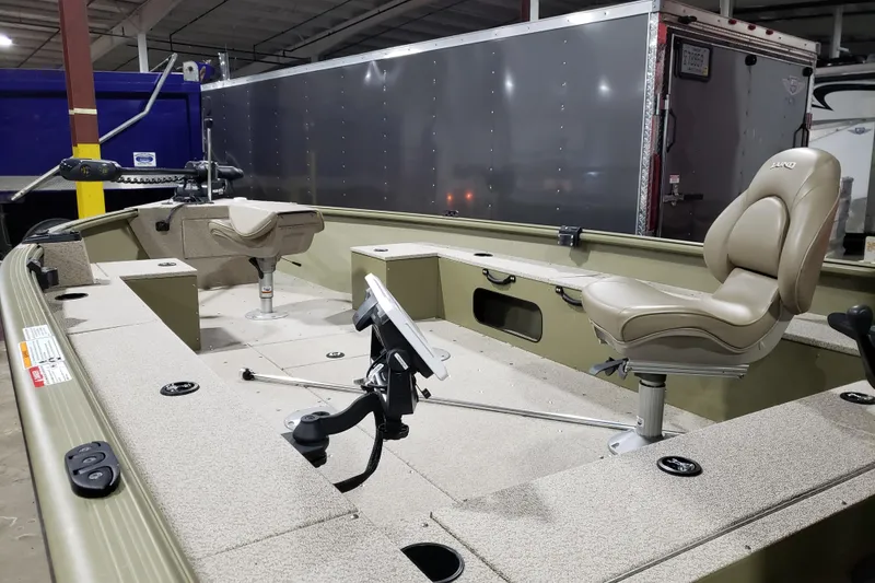 Slide: The Image of 2024 Lund 1675 Alaskan Tiller boat interior with seating and equipment in a showroom. - 1