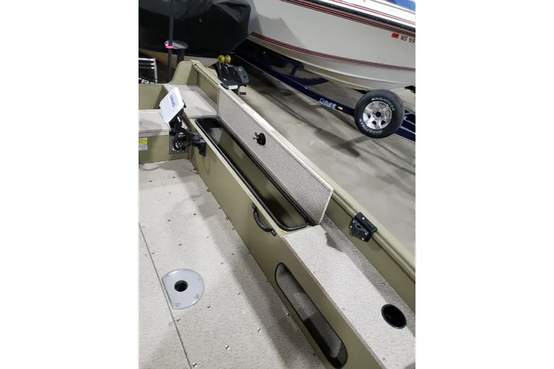 Slide: The Image of 2024 Lund 1675 Alaskan Tiller boat interior with storage compartments and seating. - 11