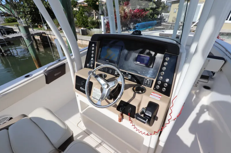 Slide: The Image of 2019 Robalo R242 Center Console boat dashboard with steering wheel and navigation controls. - 15