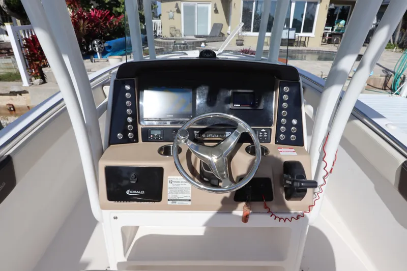 Slide: The Image of 2019 Robalo R242 Center Console boat dashboard with steering wheel and controls. - 16