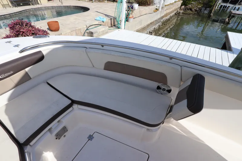 Slide: The Image of 2019 Robalo R242 Center Console boat interior with cushioned seating by the dock. - 24