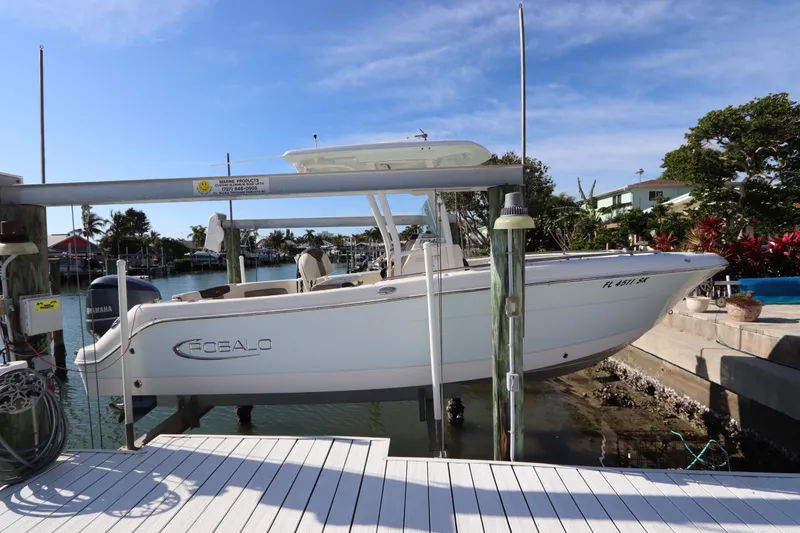 Slide: The Image of 2019 Robalo R242 Center Console boat docked by waterfront homes. - 2