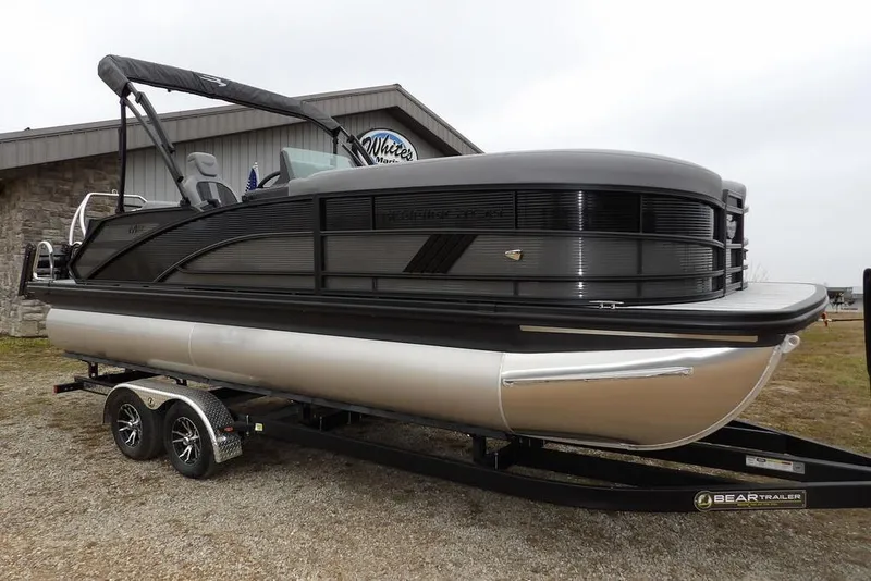 The Image of 2026 Bennington M L-Bench 22 ML pontoon boat on trailer, parked outdoors. - 1