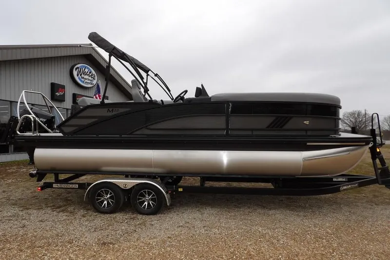 Slide: The Image of 2026 Bennington M L-Bench 22 ML pontoon boat on trailer, parked outside marine center. - 6