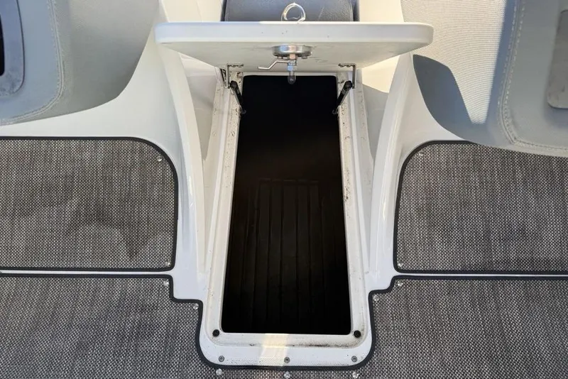 Slide: The Image of 2017 Cobalt R3 boat storage compartment with open hatch, featuring gray carpeted flooring. - 15