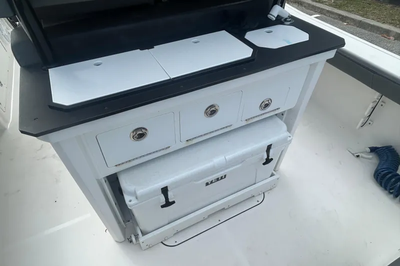 Slide: The Image of Crevalle 26 HBW 2022 boat interior with storage drawers and cooler. - 12