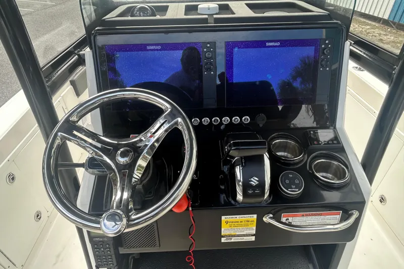 Slide: The Image of 2022 Crevalle 26 HBW boat dashboard with steering wheel and dual Simrad displays. - 14