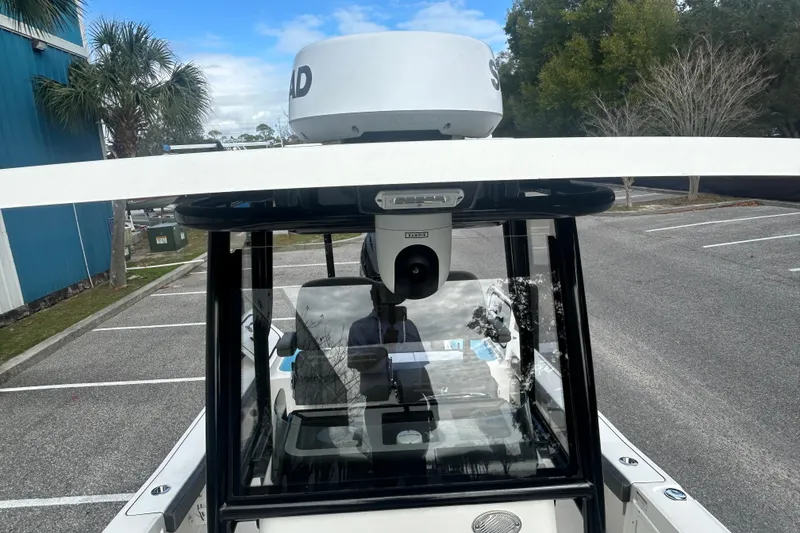 Slide: The Image of 2022 Crevalle 26 HBW boat with radar, parked in a lot under a blue sky. - 21