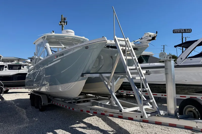 The Image of 2023 World Cat 280 DC-X boat on trailer under clear blue sky. - 0