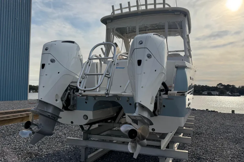 Slide: The Image of 2023 World Cat 280 DC-X boat with dual outboard engines, docked by a serene waterfront. - 2