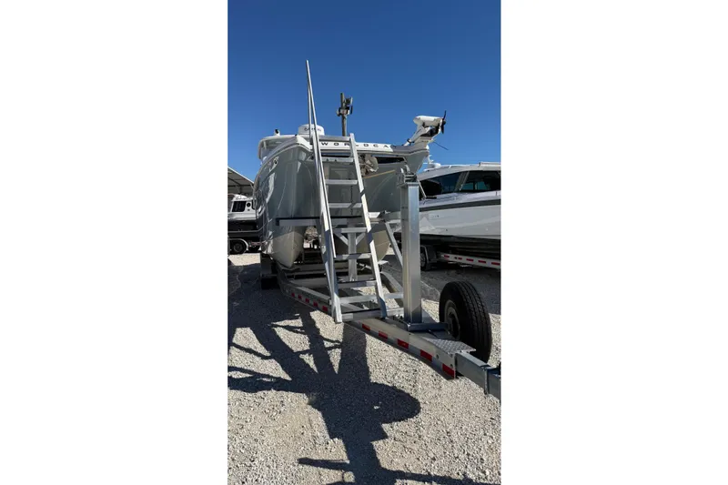 Slide: The Image of 2023 World Cat 280 DC-X boat on trailer under clear blue sky. - 25