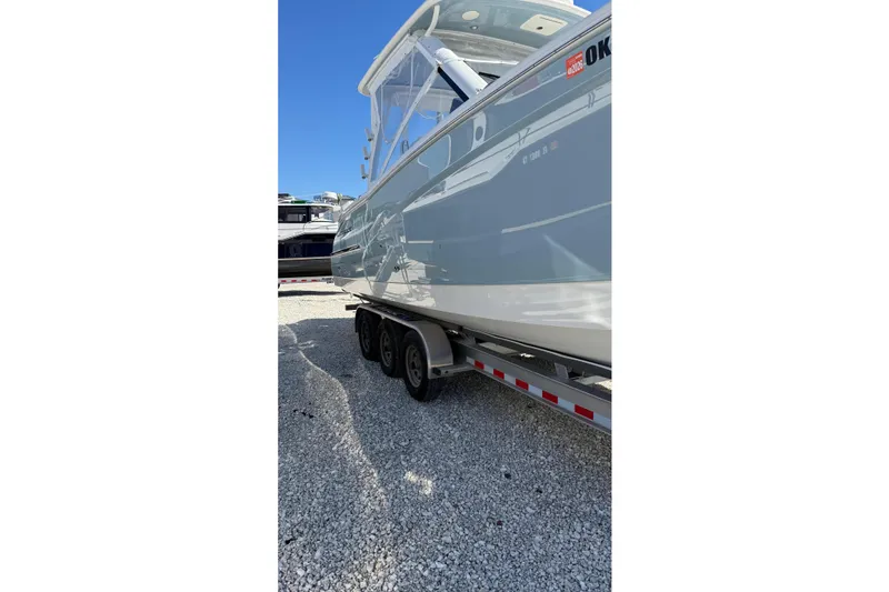 Slide: The Image of 2023 World Cat 280 DC-X boat on trailer, side view, clear blue sky. - 29