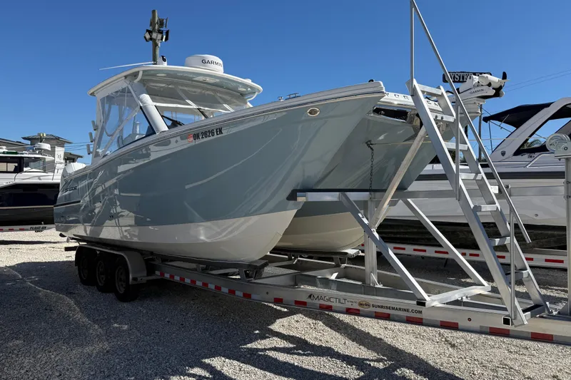 Slide: The Image of 2023 World Cat 280 DC-X boat on trailer, displayed outdoors under clear blue sky. - 30
