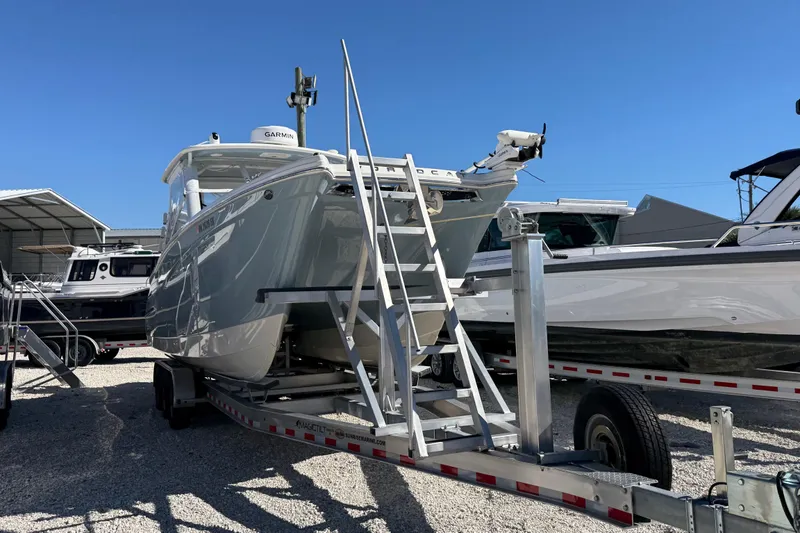 Slide: The Image of 2023 World Cat 280 DC-X boat on trailer under clear blue sky. - 31